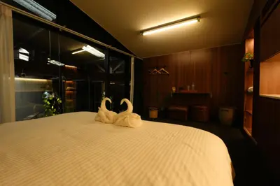 two white swans sitting on top of a bed at baansaensaep in Pratunam