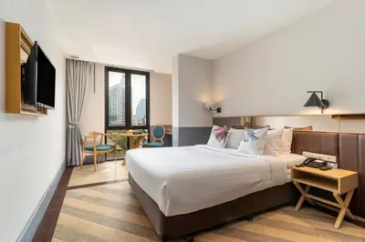 a hotel room with a bed and a tv at Vince Hotel Pratunam in Bangkok