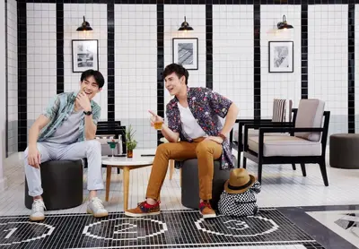 two men sitting around a table in a room at Vince Hotel Pratunam in Bangkok
