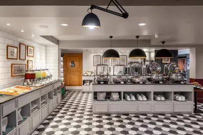 a kitchen with a counter with lots of food at Vince Hotel Pratunam in Bangkok