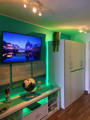 a living room with a flat screen tv on a green wall at White Turquoise -1 Bedroom Apartment- in Bangkok