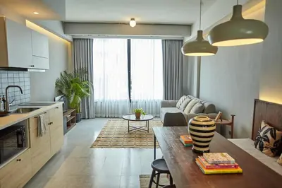 a kitchen and living room with a couch and a table at Spacious duplex 2 BR apartment max 6 guests - 3 min walk to BTS Nana in Bangkok