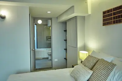 a bedroom with a bed and a bathroom with a toilet at Stylish duplex 2 BR apartment - 3 mins walk to BTS Nana in Bangkok