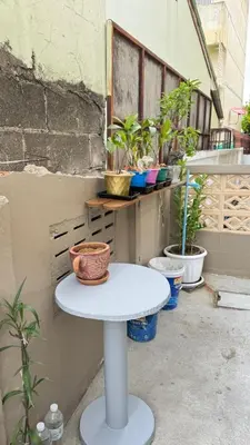 a small white table with plants on a balcony at 94Home Donmuang in Bang Khen