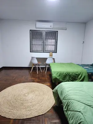 a room with two beds and a table and chairs at Creative Bangkok twin bed in Sathani Bang Khen
