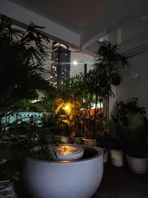 a room with potted plants and a fountain in a building at Creative Bangkok twin bed in Sathani Bang Khen