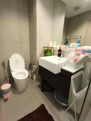 a bathroom with a white sink and a toilet at Luxury Riverside Condo, 3 SKY Pools , Close to MRT Train Station in Ban Sai Ma