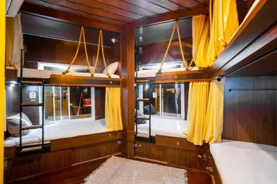 a room with two windows and yellow curtains at OYO 895 The Onion Hostel in Bangkok
