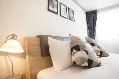 a bedroom with a bed with pillows and a lamp at Oh Boutique Guesthouse. in Bangkok