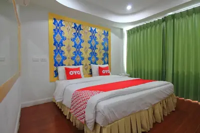 a bedroom with a large bed with green curtains at OYO 410 Diamond Boutique Hostel in Bangkok