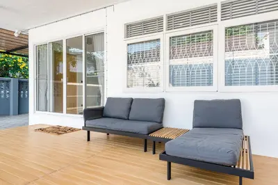 two chairs and a couch in a room with windows at Coco59- Private 3BR Pool Villa in Bangkok