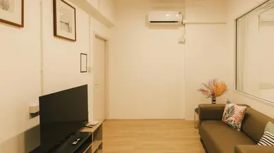 a living room with a couch and a flat screen tv at City Silom I King Bed I Sleep 3 I 2 Bedroom in Bangkok