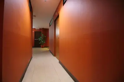 a hallway with orange walls and a tile floor at Super OYO 484 Pannee Residence Khaosan Sha Plus in Bangkok