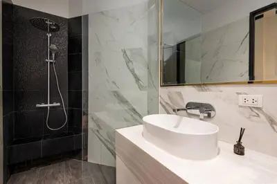 a bathroom with a sink and a shower at Stylish 7Beds Poolhouse with Cinema Lift - 2min to BTS in Amphoe Phra Khanong