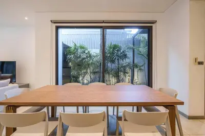 a conference room with a wooden table and chairs at MonochromeDesignerPool Villa in Bangkok