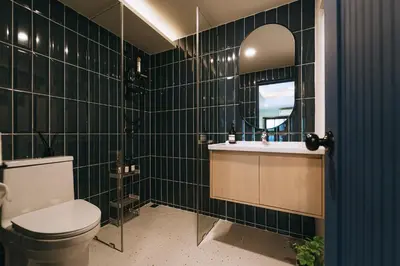 a bathroom with a toilet and a sink and a mirror at HAUS 924 l 5-Level Sanctuary in Ekkamai in Bangkok