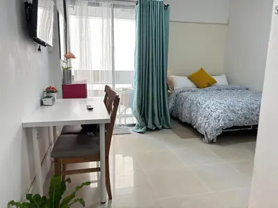 a bedroom with a bed and a desk and a window at Tiny Nest Pratunum Airport Link in Pratunam