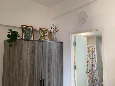 a cabinet with pictures on top of it in a bathroom at Tiny Nest Pratunum Airport Link in Pratunam