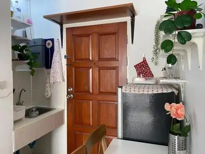 a small kitchen with a door and a sink at Tiny Nest Pratunum Airport Link in Pratunam