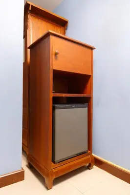 a small wooden cabinet with a glass door at Elite Home stays by UPAR, Silom in Bangkok
