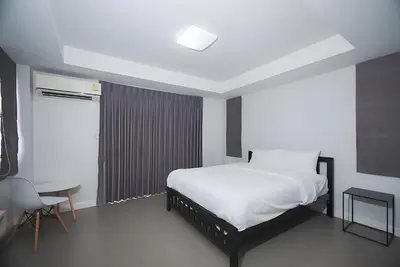 a bedroom with a bed and a table and a chair at XX Mitr Inn The Grand Palace Bangkok - Samyot in Bangkok
