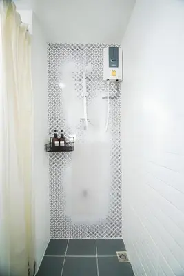 a shower in a white bathroom with a shower curtain at XX Mitr Inn The Grand Palace Bangkok - Samyot in Bangkok