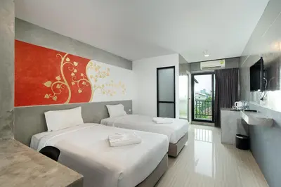 a hotel room with two beds and a television at The Riche Boutique Hotel Don Mueang Airport in Bangkok