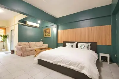 a bedroom with a large bed and a couch at XX GO INN The Grand Palace - MRT Samyot Station in Bangkok