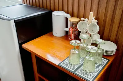 a table with glasses and plates on a counter at Via Baan Sathorn, City-Center Apartment With Private Rooftop Near BTS in Bangkok