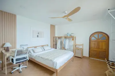 a bedroom with a bed and a desk and a fan at Via Baan Sathorn, City-Center Apartment With Private Rooftop Near BTS in Bangkok