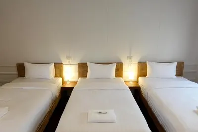 two beds in a room with lights on them at Au samlor guesthouse in Chinatown