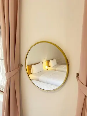 a mirror on a wall with a bed in a room at Au samlor guesthouse in Chinatown