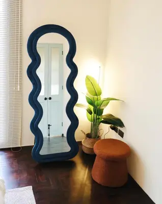 a mirror in a room with a plant and a stool at Charming Minimal 3BR Home Near BTS Ari, Bangkok in Sathani Bang Su