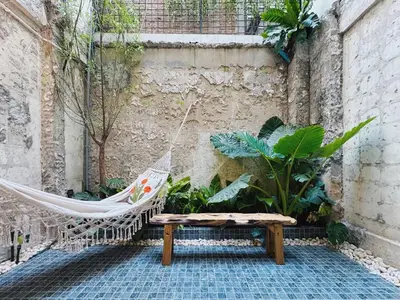 a hammock and a bench in a courtyard with plants at Charming Minimal 3BR Home Near BTS Ari, Bangkok in Sathani Bang Su