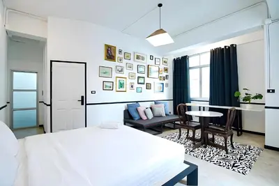 a white bedroom with a bed and a table and chairs at XX The Character China Town - เดอะ คาแรคเตอร์ เยาวราช in Samphanthawong