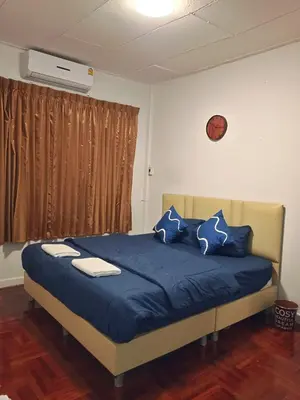 a bedroom with a bed with blue sheets and blue pillows at ESSENCE Home in Bangkok