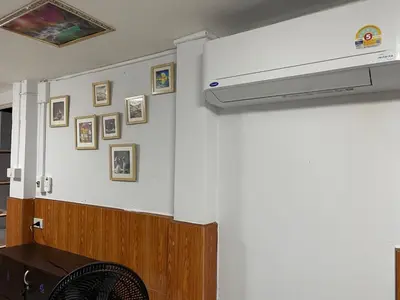 a living room with a wall with a stove and pictures at ESSENCE Home in Bangkok