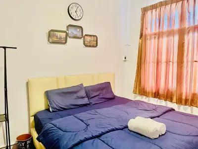 a bedroom with a bed and a clock on the wall at ESSENCE Home in Bangkok