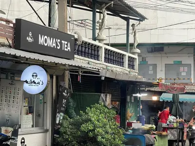 a sign for aumes tea shop in an asian street at ESSENCE Home in Bangkok