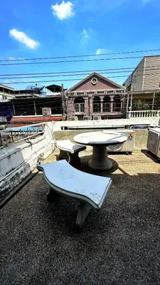 a table and benches on top of a roof at ESSENCE Home in Bangkok
