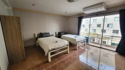 a room with two beds and a large window at Tawan Room#5 in Bangna