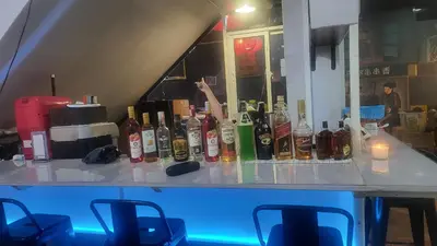 a bar with bottles of alcohol on a counter at Tawan Room#5 in Bangna