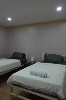 a room with two beds and a wall at Tawan Room#6 in Bangna