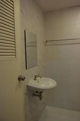 a white bathroom with a sink and a mirror at Tawan Room#6 in Bangna