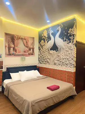 a bedroom with a bed with a painting on the wall at Asia Mahanakhorn Travel in Bangkok