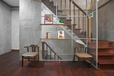 two chairs sitting in a room with stairs at Siam Breeze Inn - Self Check-in in Bangkok