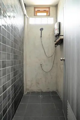 a shower with a hose attached to a wall at Siam Breeze Inn - Self Check-in in Bangkok
