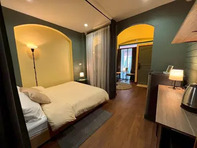 a bedroom with a white bed and a green wall at Hansa Heritage home in Khao San in Bangkok