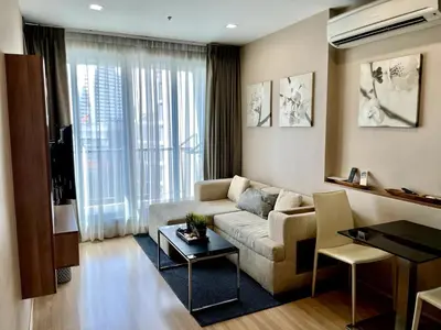 a living room with a couch and a table at Condo, 3-min walk to BTS, Sky pool, Gym, Wifi, Self check-in at pickup point in Bangkok