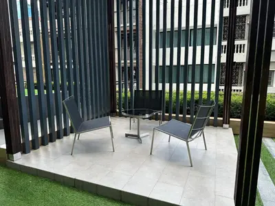 a patio with two chairs and a table in a building at Condo, 3-min walk to BTS, Sky pool, Gym, Wifi, Self check-in at pickup point in Bangkok
